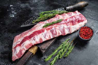 Çiğ kuzu fileto pirzola. Kesme tahtasında bıçakla. Siyah arka plan. Üst görünüm