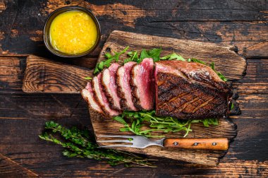 Dilimlenmiş ördek eti göğüs bifteği. Koyu ahşap arka plan. Üst görünüm