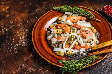 Karides, karides, midye, mürekkep balığı ve ahtapotlu deniz ürünleri kokteyli. Koyu ahşap arka plan. Üst Manzara. Boşluğu kopyala