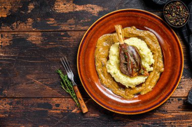 Güveçte kuzu Shanks ve patates püresi. Siyah arka plan. Üst Manzara. Boşluğu kopyala