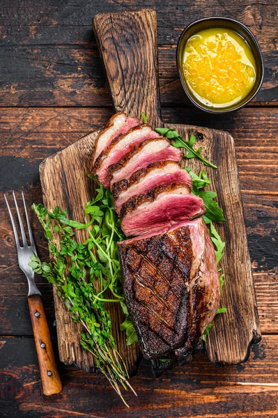 Dilimlenmiş ördek eti göğüs bifteği. Koyu ahşap arka plan. Üst görünüm