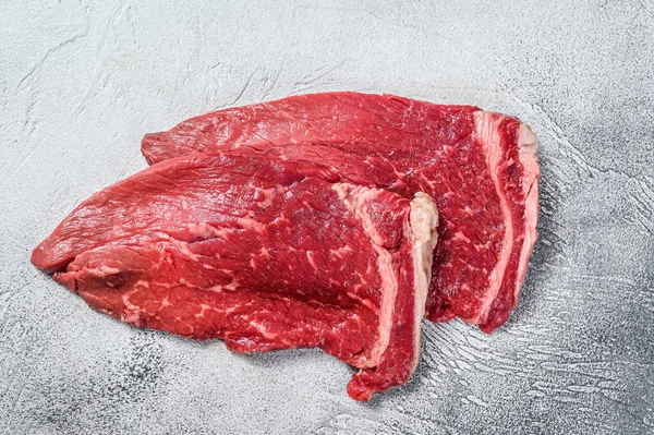 生の新鮮な仔牛の肉をステーキを切る。白地だ。トップ表示 — ストック写真