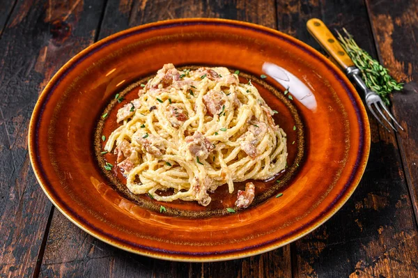 Итальянская спагетти-карбонара с беконом, твердым сыром пармезан и сливочным соусом. Темный вуден фон. вид сверху — стоковое фото
