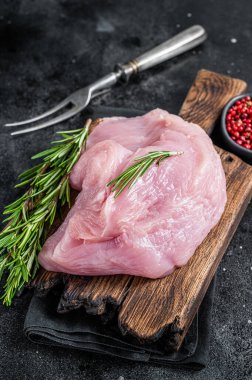 Taze çiğ büyük hindi göğsü filetosu tahtada. Siyah arka plan. Üst Görünüm