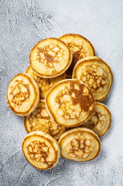 Mutfak masasında bir yığın tereyağlı krep. Beyaz arka plan. Üst Görünüm