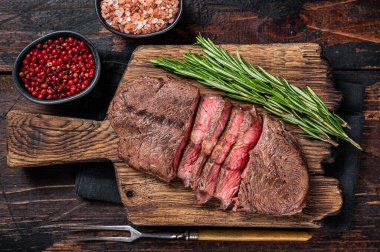Kızarmış Top Blade ya da ahşap tahtada biberiyeli dana eti bifteği. Koyu ahşap arka plan. Üst Görünüm
