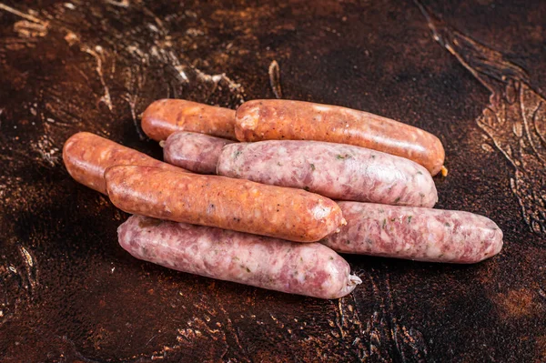 Surowe kiełbaski z grilla Chorizo i Bratwurst z przyprawami. Mroczne tło. Widok z góry — Zdjęcie stockowe