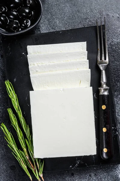 Greek cheese feta with rosemary and olives. Black background. Top view — Stock Photo, Image