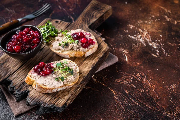 Eend rillettes paté toast met spruitjes op een houten plank. Donkere achtergrond. Bovenaanzicht. Kopieerruimte — Stockfoto