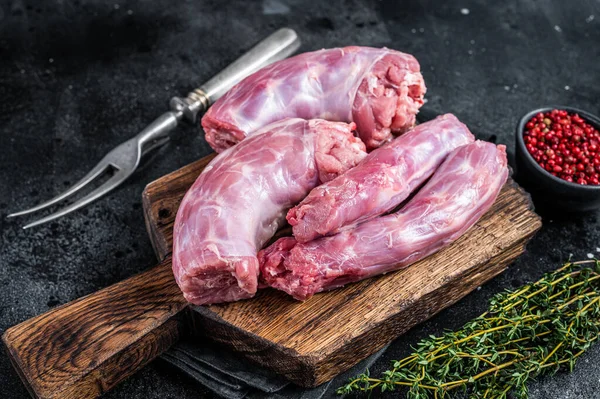 Rått kalkonhalskött på en slaktarbräda. Svart bakgrund. Ovanifrån — Stockfoto