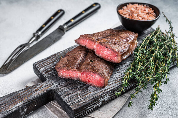 Roasted Shoulder Top Blade or flat iron beef meat steaks on wooden board. White background. Top View