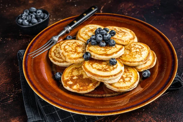 Piring dengan pancake dengan blueberry segar dan sirup. Latar belakang gelap. Tampilan Atas — Stok Foto