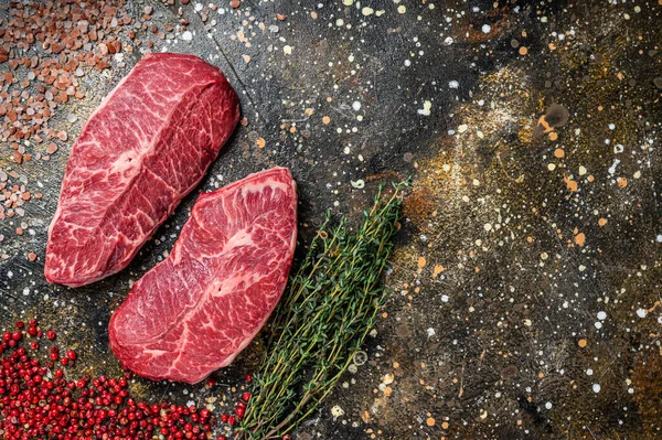 Çiğ omuz üstü bıçaklı kesikler, biftekli biftekler. Kahverengi arka plan. Üst Manzara. Boşluğu kopyala