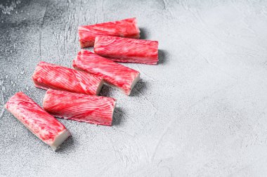 Yengeç surimi mutfak masasına yapışıyor. Beyaz arka plan. Üst Manzara. Boşluğu kopyala