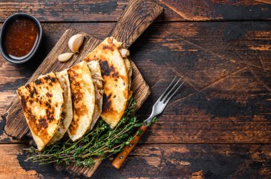 Tavuk, paprika, peynir ve kişniş soslu Meksika quesadilla 'sı. Koyu ahşap arka plan. Üst Manzara. Boşluğu kopyala