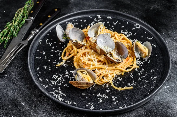 Pasta de espaguetis de mariscos con vongole de almejas en un plato. Fondo negro. Vista superior —  Fotos de Stock