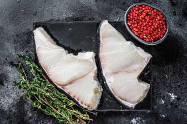 Tahtada çiğ köpekbalığı bifteği. Siyah arka plan. Üst görünüm