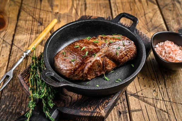 Grilled veal fillet meat steak in a pan with herbs. wooden background. Top view — Stock Photo, Image