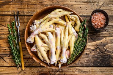 Tahta tabakta çiğ tavuk ayağı. Ahşap arka plan. Üst görünüm