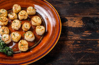 Tabakta tereyağlı baharat soslu kızarmış istiridye. Koyu ahşap arka plan. Üst Manzara. Boşluğu kopyala