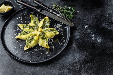 Biftek ve ıspanakla doldurulmuş İtalyan Jumbo kabuklu Conchiglioni makarnası. Siyah arka plan. Üst Manzara. Boşluğu kopyala