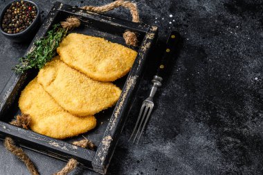 Tahta tepside otlarla birlikte çiğ tavuk cordon bleu et pirzolası. Siyah arka plan. Üst Manzara. Boşluğu kopyala