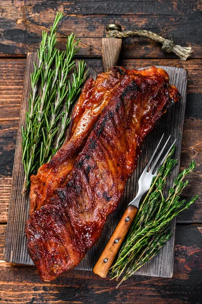 Churrasco grelhado vitela carne de peito de vitela em costela de reposição curta na placa de corte de madeira. Fundo de madeira escuro. Vista superior — Fotografia de Stock