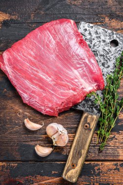 Çiğ etek, satırda mermer biftek. Karanlık ahşap arka plan. Üst görünüm
