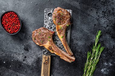 Kasap satırında ızgara kuzu pirzolası. Siyah arka plan. Üst görünüm