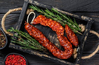 Dilimlenmiş sucuklu salam, İspanyol geleneksel sucuklu sosisi. Siyah ahşap arka plan. Üst görünüm