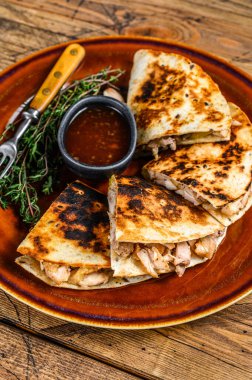 Tavuk, paprika, peynir ve kişniş soslu Meksika quesadilla 'sı. Koyu ahşap arka plan. Üst görünüm