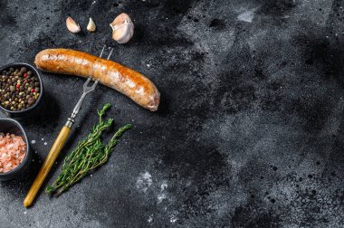 Et çatalında baharat ve otlarla kızartılmış sosis ızgarası. Üst Manzara. Siyah arka plan. Boşluğu kopyala