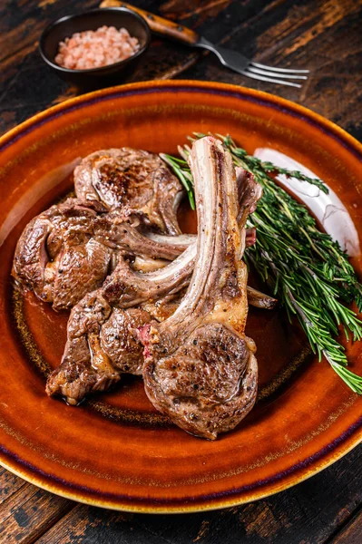 BBQ carne di agnello alla griglia costolette di carne di montone bistecche su un piatto. Fondo in legno scuro. Vista dall'alto — Foto Stock