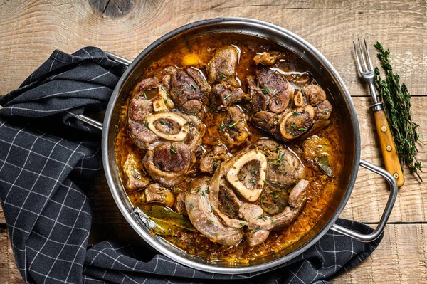 Dana budu, Osso Buco, İtalyan ossobuco bifteği. Ahşap arka plan. Üst görünüm