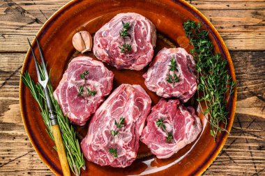 Kuzu boynunda, kekik ve biberiyeli kuzu eti. Ahşap arka plan. Üst görünüm