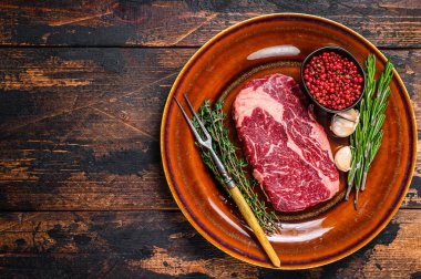 Kırsal bir tabakta siyah angus bifteği. Koyu ahşap arka plan. Üst Manzara. Boşluğu kopyala