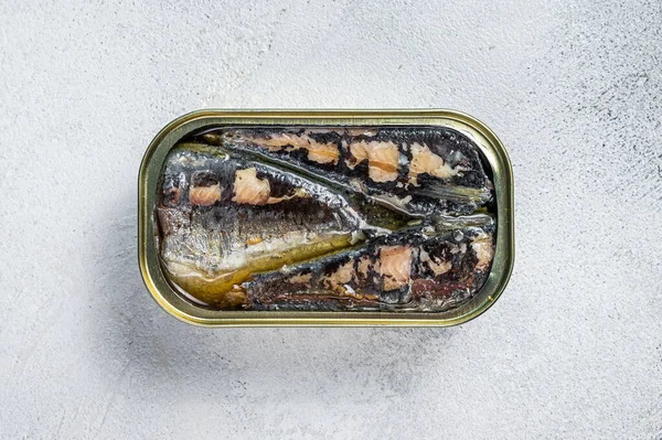 Open can with sardine in olive oil. White background. Top view