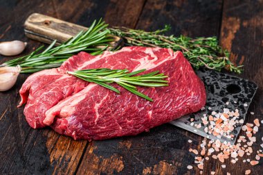 Çiğ Chuck 'ın gözü kasap satırında Black Angus bifteği. Koyu ahşap arka plan. Üst görünüm