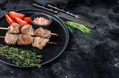 Şiş kebaplar bir tabakta ızgara et ve sebze. Siyah arka plan. Üst Manzara. Boşluğu kopyala