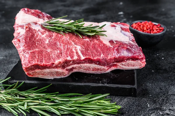 Mermer tahtada çiğ sığır pirzolası kalbi. Siyah arka plan. Üst görünüm