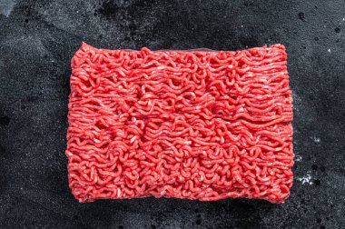 Mutfak masasında çiğ kıyma eti. Siyah arka plan. Üst görünüm