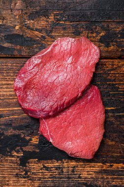 Çiğ siyah angus bifteği. Koyu ahşap arka plan. Üst görünüm