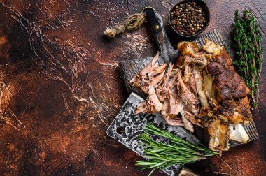 Kızartılmış ve et satırıyla ahşap bir tahtanın üzerinde Alman domuz budu Eisbein eti. Karanlık arka plan. Üst Manzara. Boşluğu kopyala