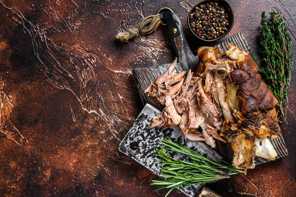 Kızartılmış ve et satırıyla ahşap bir tahtanın üzerinde Alman domuz budu Eisbein eti. Karanlık arka plan. Üst Manzara. Boşluğu kopyala