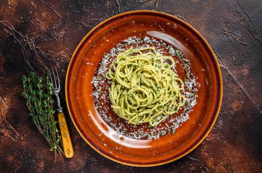 Pesto soslu ve parmesanlı ıspanaklı spagetti. Karanlık arka plan. Üst görünüm
