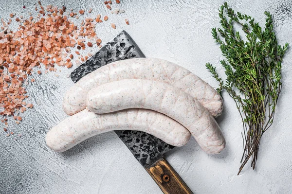 Bavarian traditional white sausages on a meat cleaver. White background. Top view