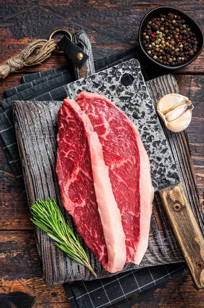 Tapa de solomillo superior cruda filetes de carne de res en el carnicero con cuchilla de carne. Fondo de lana oscura. Vista superior —  Fotos de Stock