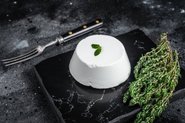 Ricotta krem peyniri kekikli mermer tahtada. Siyah arka plan. Üst görünüm