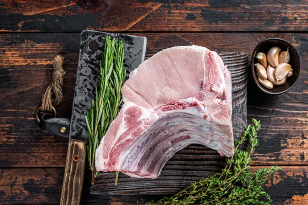Et satırıyla kasap tahtasında pirzola ve domuz filetosu. Koyu ahşap arka plan. Üst görünüm — Stok fotoğraf