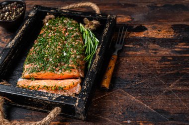 Somon Gravlax, ahşap tepside tuz ve dereotla tedavi edilir. Koyu ahşap arka plan. Üst Manzara. Boşluğu kopyala